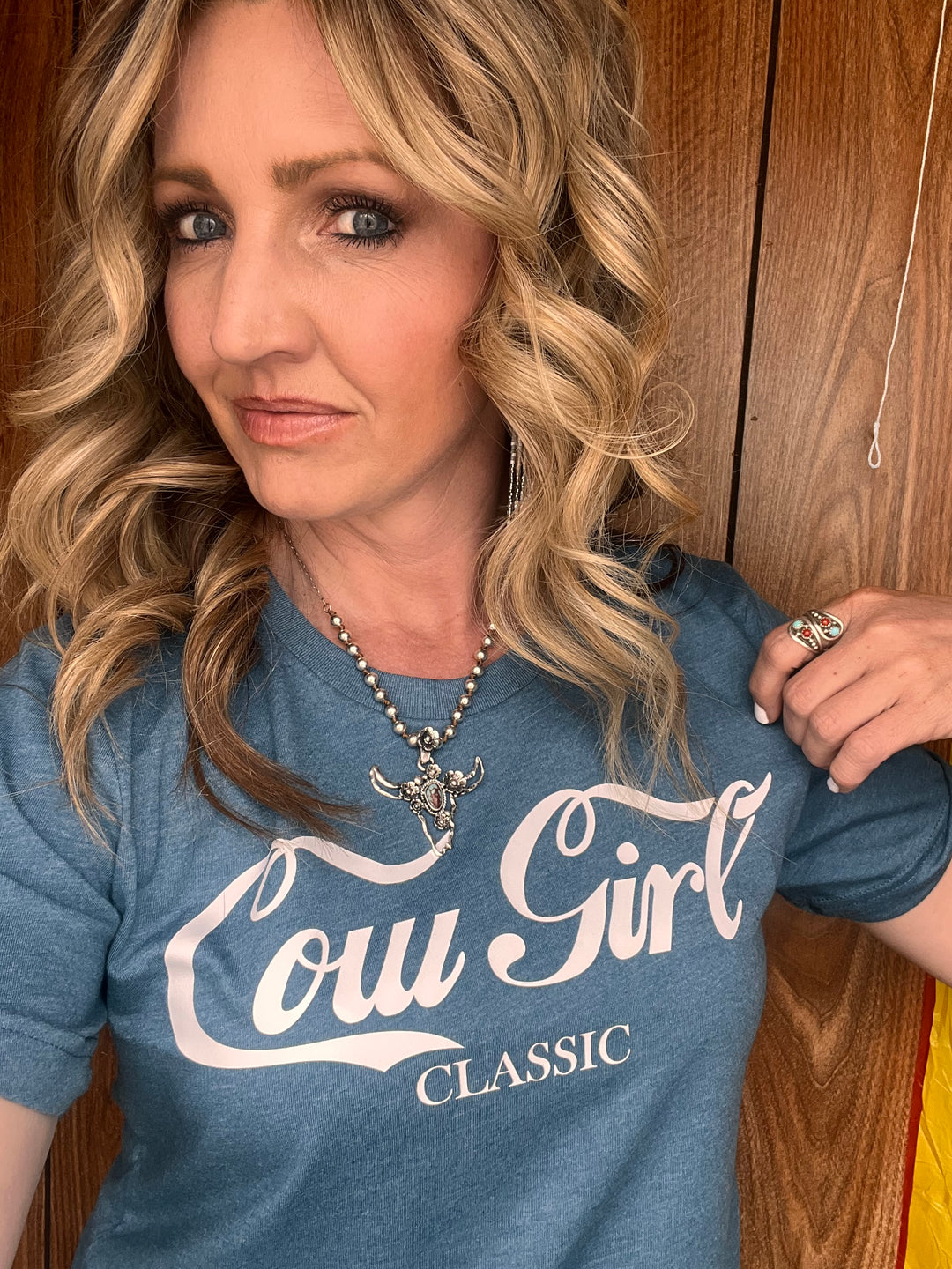 A person wearing a blue graphic tee with &