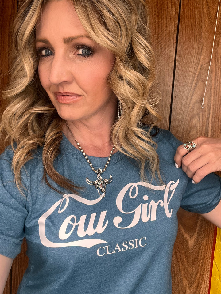 A person wearing a blue graphic tee with &