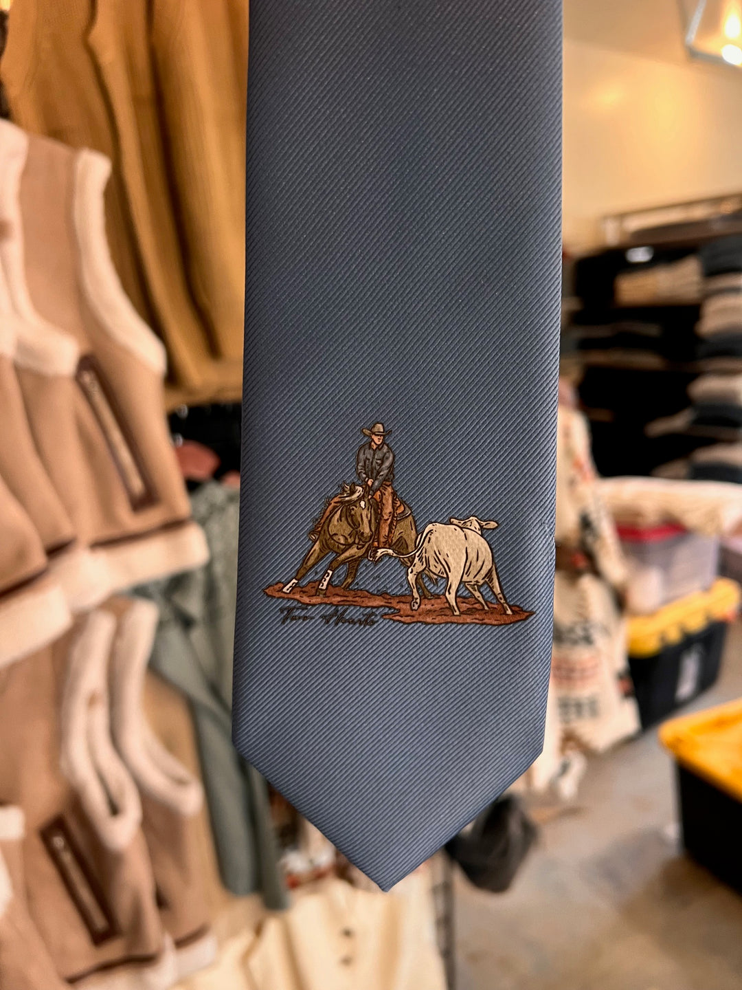 Gray tie with embroidered design in a clothing store setting