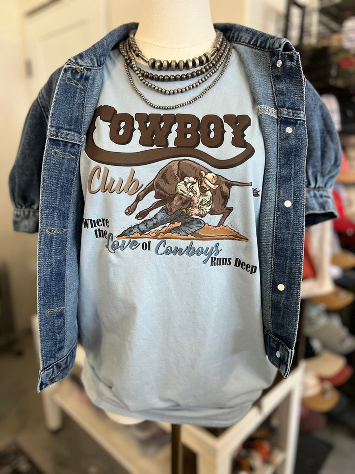 Mannequin wearing a denim jacket over a t-shirt with a cowboy graphic and text.
