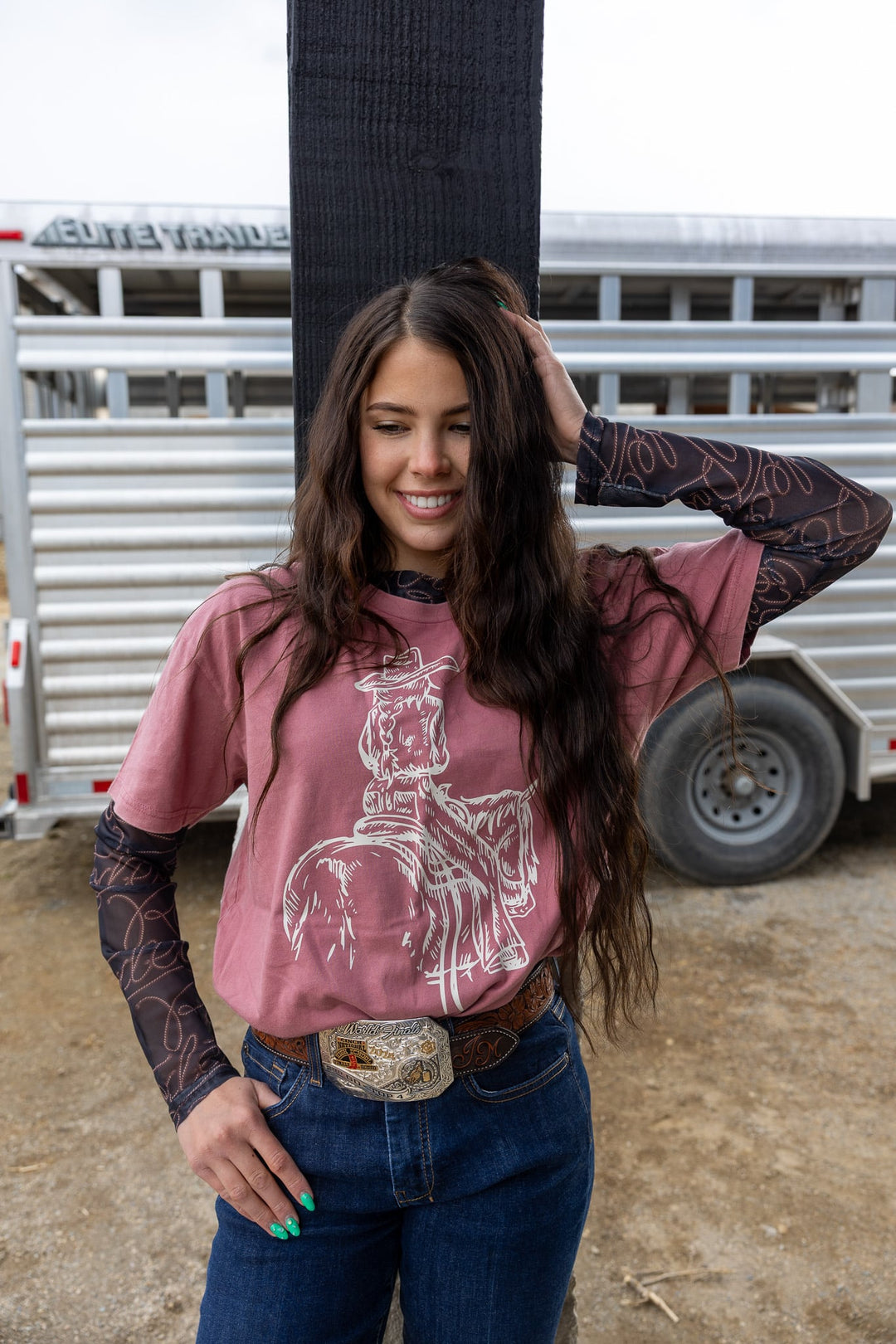 Woman wearing a pink shirt with a horse graphic in an outdoor setting