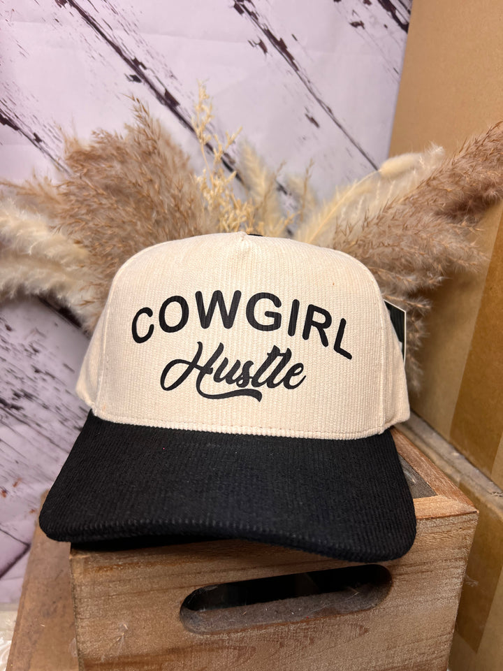 A ballcap with a khaki crown and black bill, featuring the text &