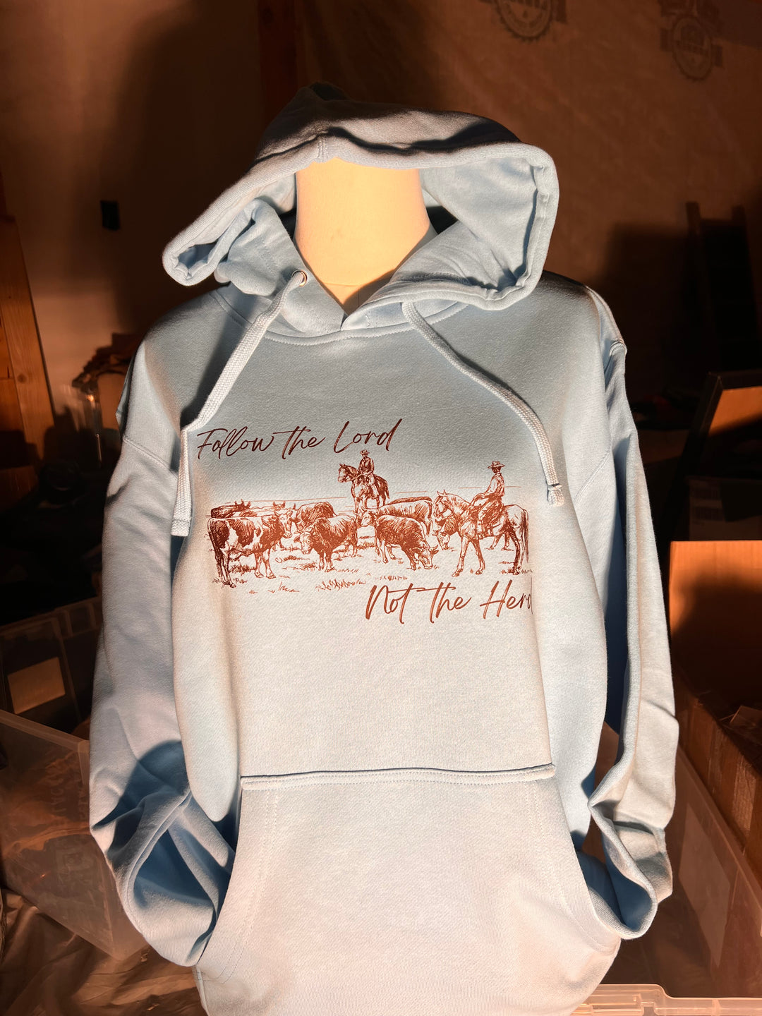Light gray hoodie with text and graphics on a wooden surface