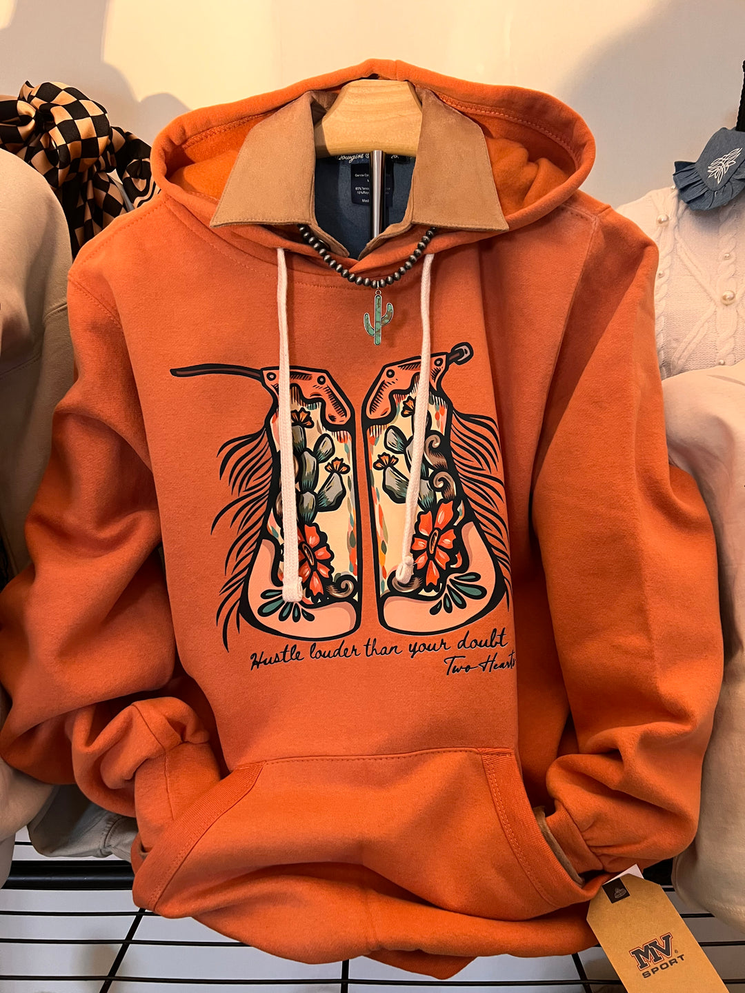 Orange hoodie with graphic design on a light background