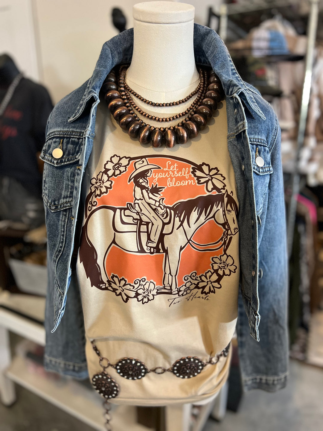 Mannequin wearing a denim jacket with a graphic t-shirt featuring a horse and text.