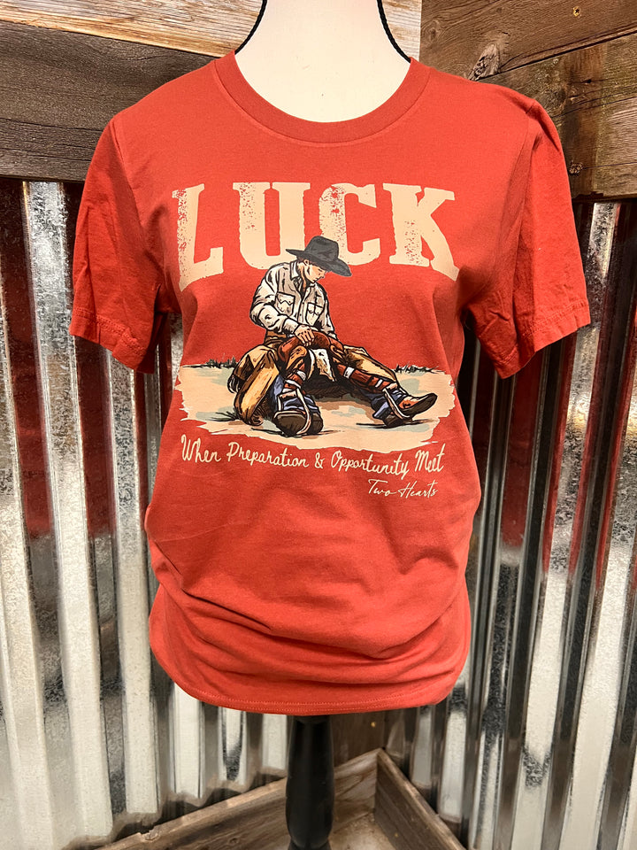 Red t-shirt with graphic design and text on a metal surface