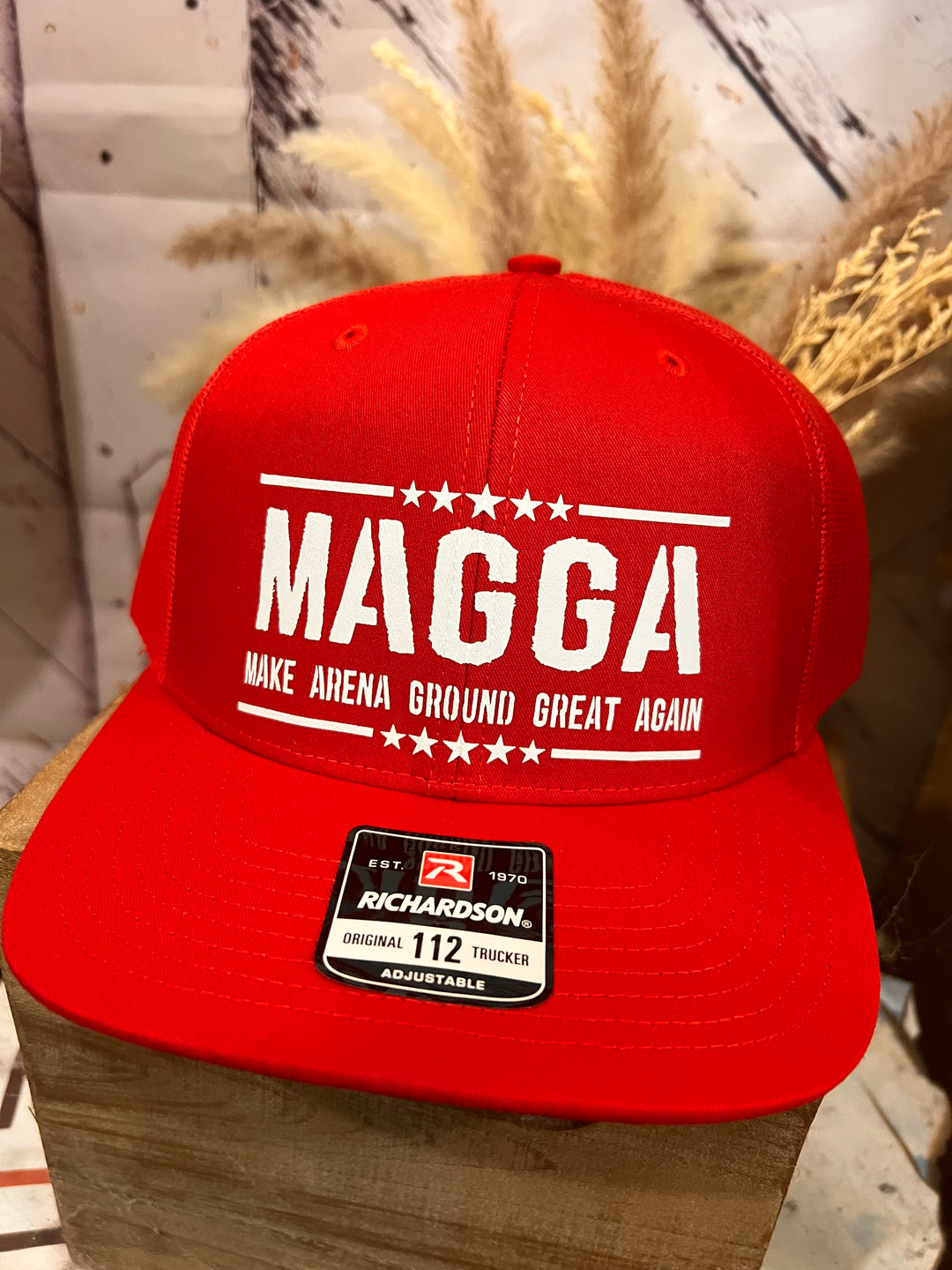 Red cap with 'MAGGA' text and Richardson logo on a wooden surface.