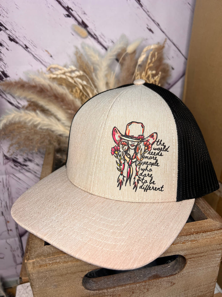 A beige and black trucker cap with a design of a cowgirl and the text &