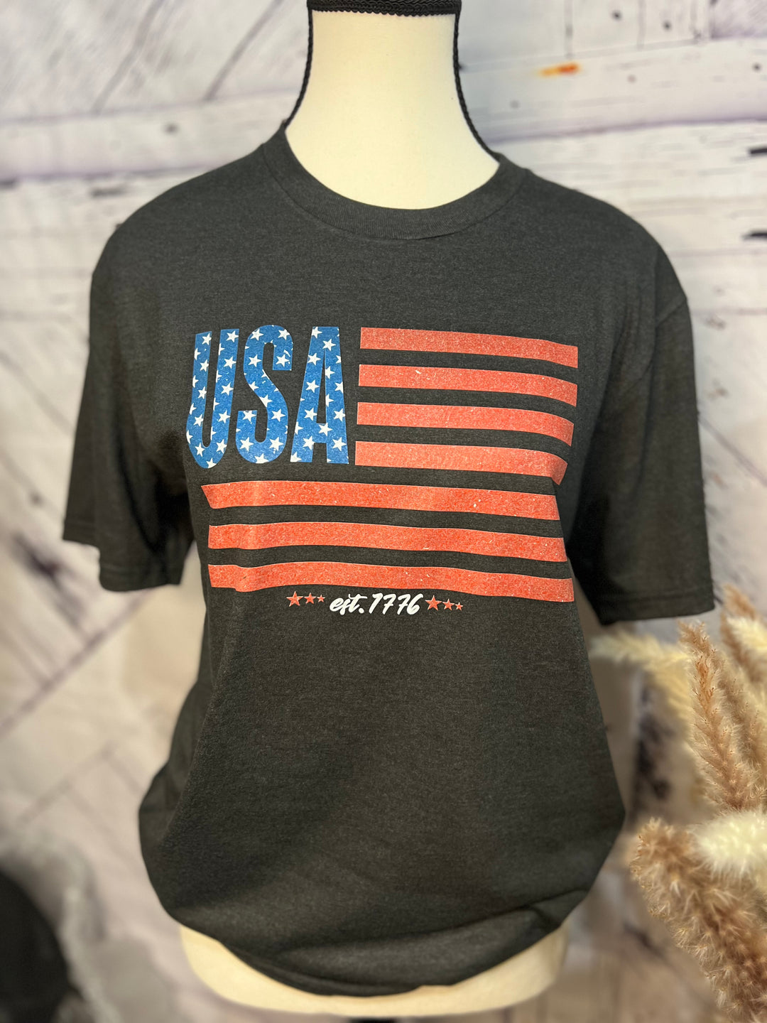 A black graphic tee with a printed American flag motif and the text 'USA' on the front.