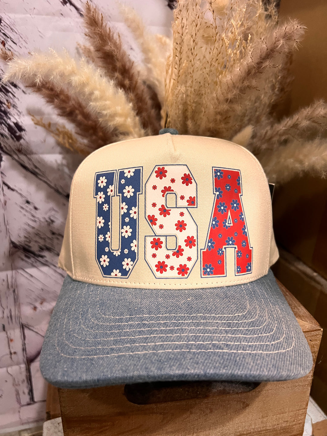 A beige and denim ballcap with a patriotic floral USA design in red, white, and blue.