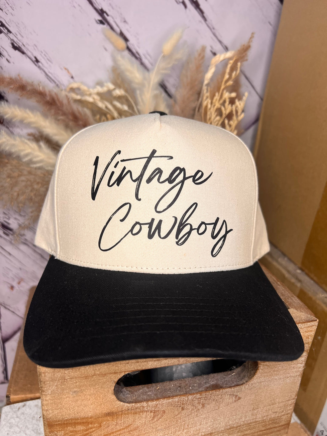 A beige and black C.C. brand ballcap with the words 'Vintage Cowboy' written in a classic bold font on the front.