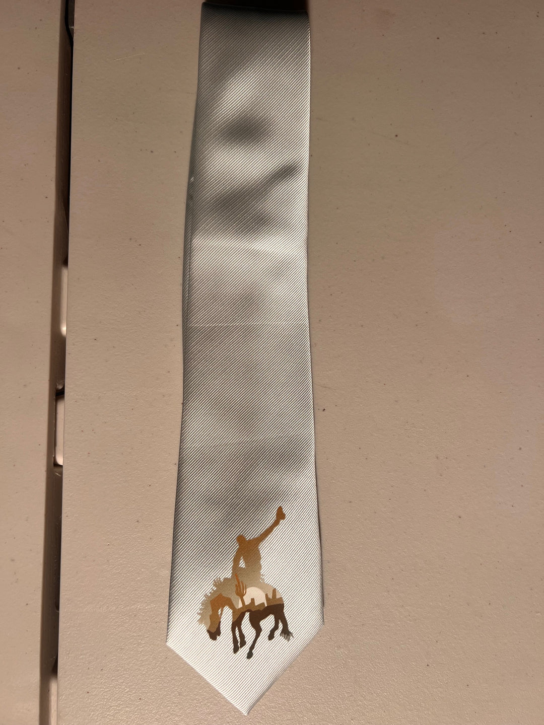 White tie with a horse design on a beige background