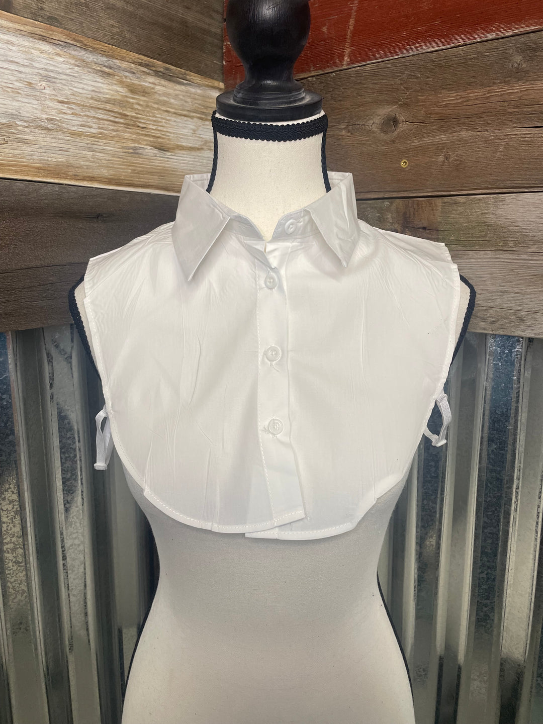 White dress on a mannequin against a wooden and metal background
