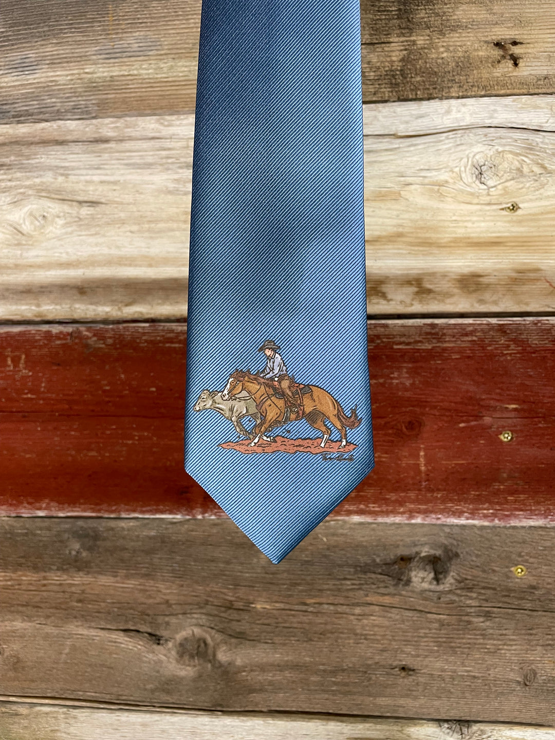 Blue tie with an embroidered design on a wooden surface