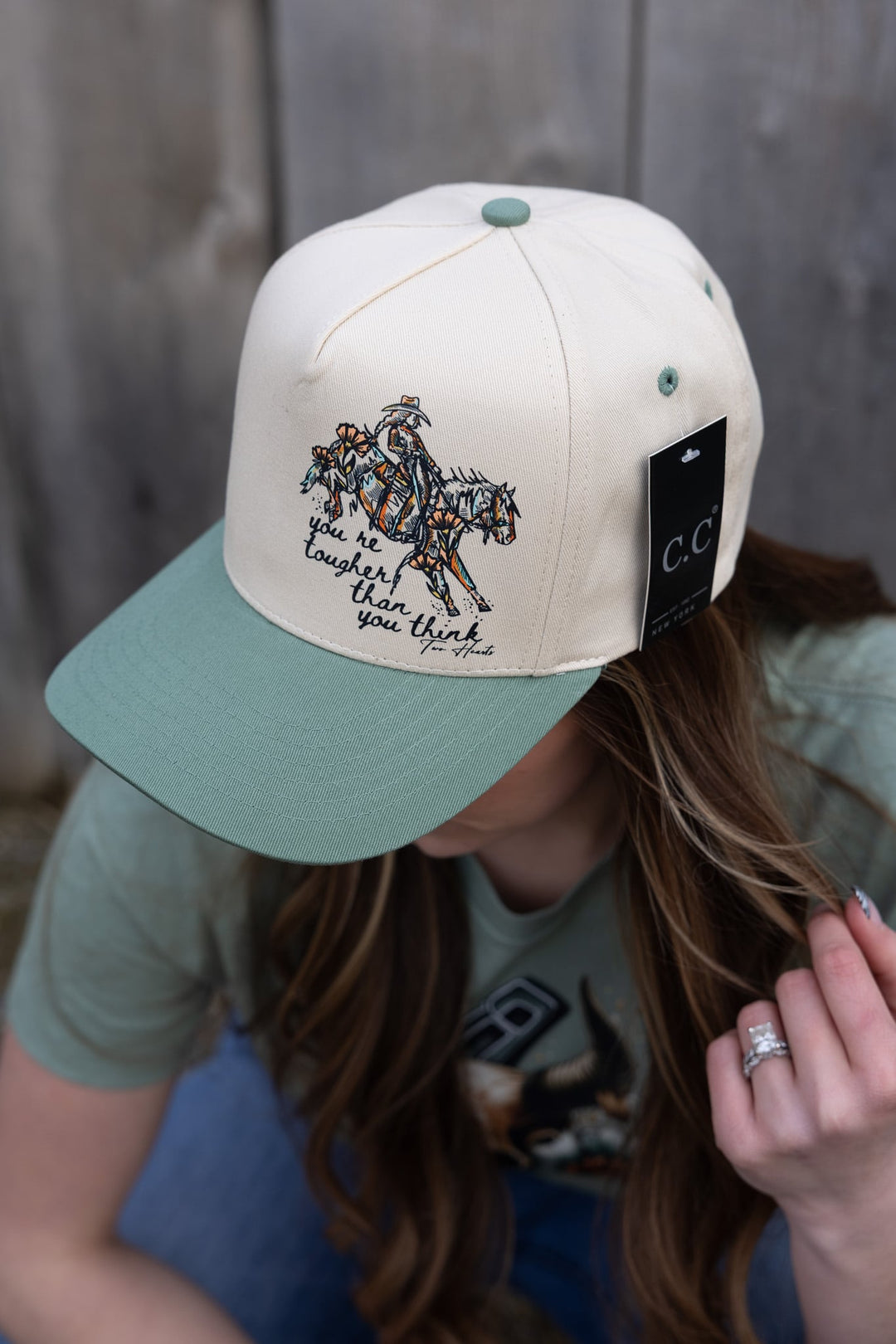 Person wearing a cap with a horse and rider design and 'CC' branding.