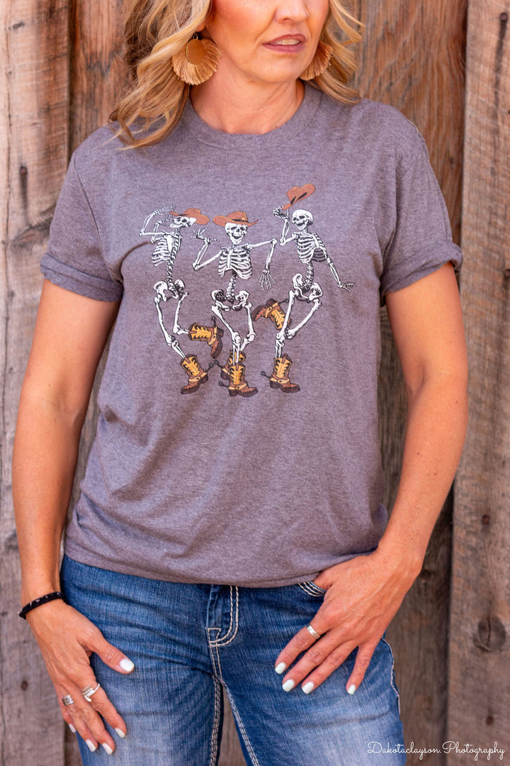 A person wearing a gray graphic tee with a skeleton design.