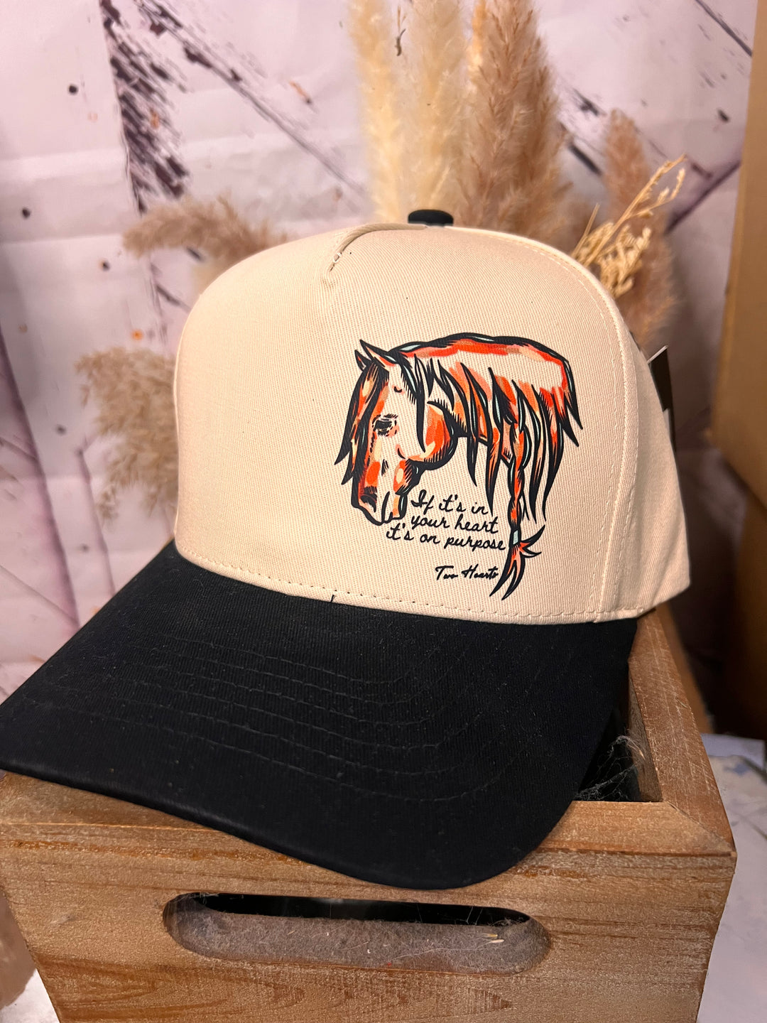 Cap with a horse design on a wooden stand