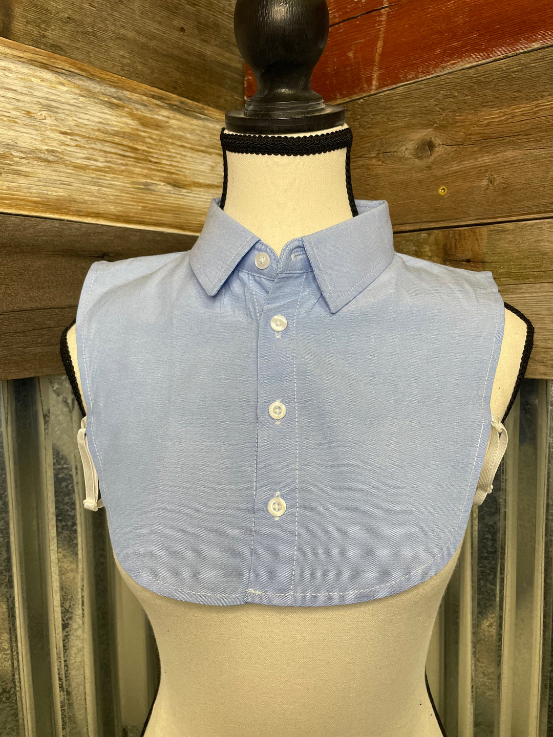 Light blue dress shirt on a mannequin with wooden background