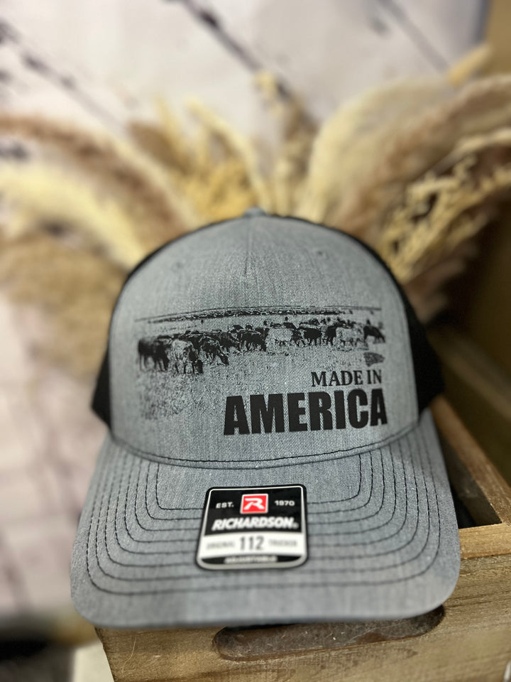 Two ballcaps, one brown and one white, with &