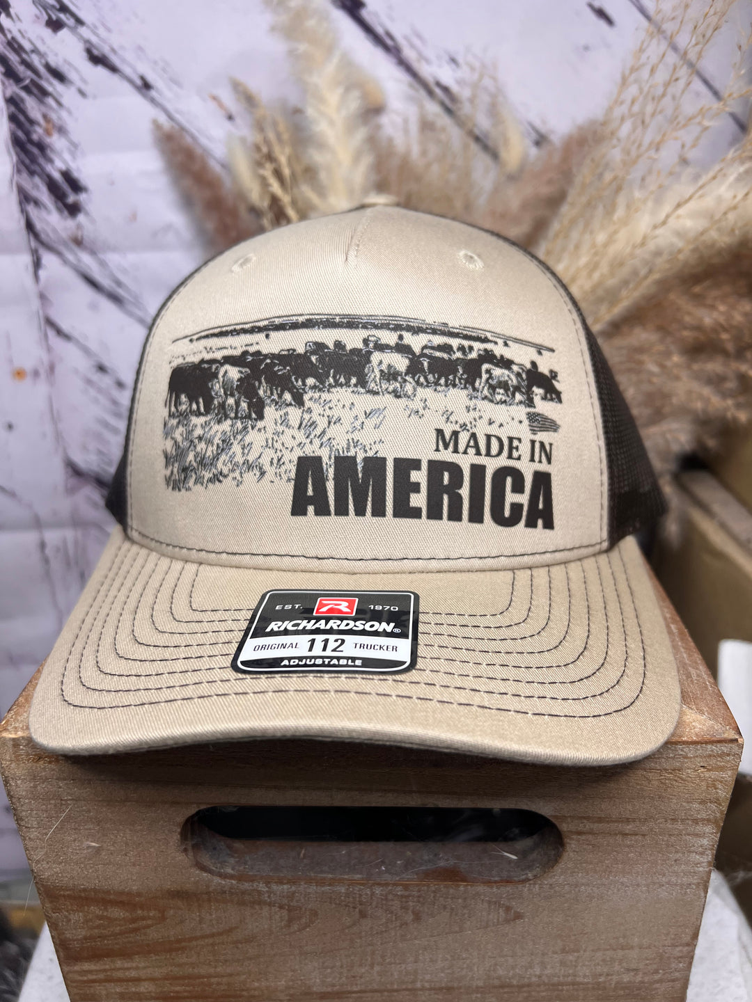 Two ballcaps, one brown and one white, with &