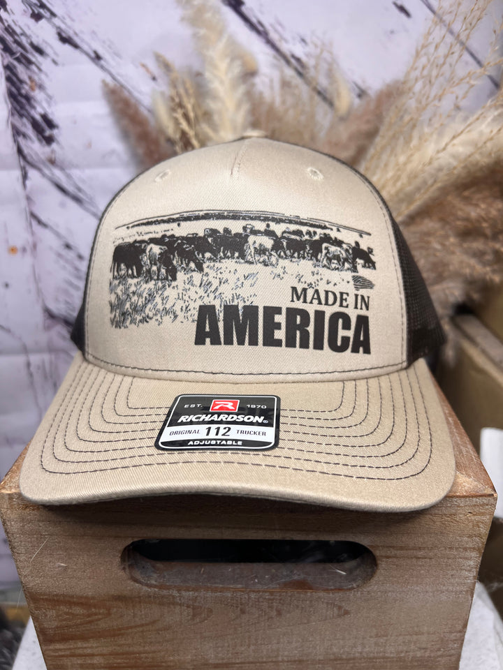 Two ballcaps, one brown and one white, with &