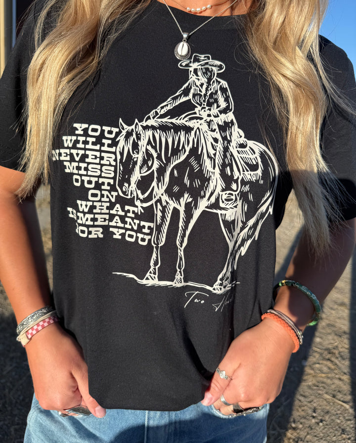 Person wearing a black t-shirt with a graphic of a cowgirl on a horse and text.
