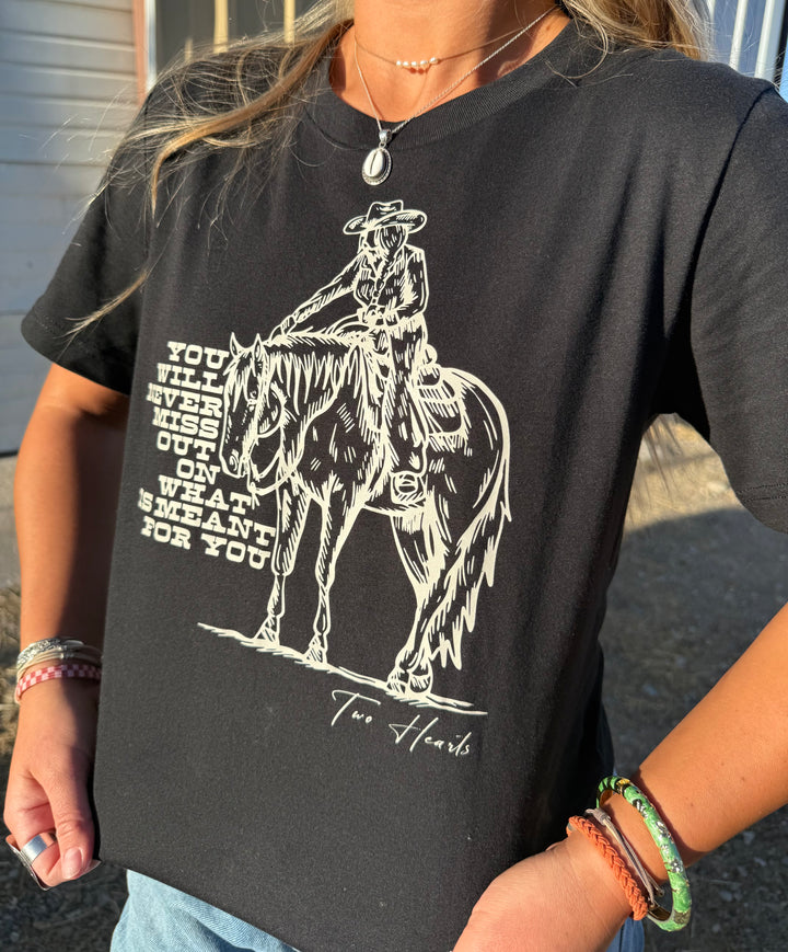 Person wearing a black t-shirt with a graphic of a rider on a horse and text.